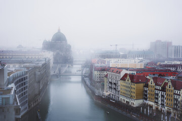 Der Berliner Dom bei Nebel mit der Spree im Vordergrund und anderen Gebäuden © Philip