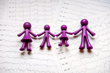 International Epilepsy Day, Epilepsy awareness. Purple toy adults and kids people, family on brain wave on electroencephalogram EEG for epilepsy