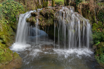 Fototapeta premium Water flow over tufa rock and makes small waterfall on Una river in Una national park near Martin Brod