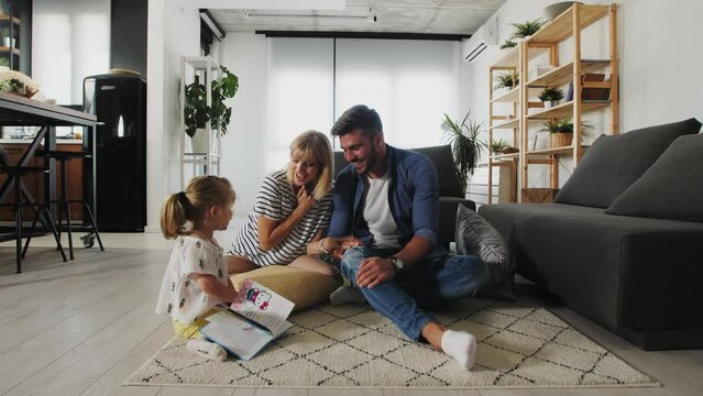 Little girl is reading book with parents