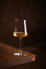 Glass of white wine on wooden table in restaurant interior