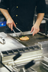 Chef in the Kitchen of the Restaurant prepares dishes for serving to guests