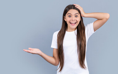 photo of surprised teen girl with long hair wearing tshirt. teen girl isolated on grey.