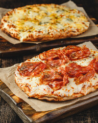 Two Roman-style pizzas with cheese and jamon serrano. Roman square pizza or Pinsa on thick dough, Italian cuisine