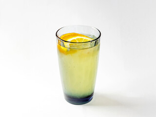 Refreshing lemonade from lemons in glass of colored glass on white background