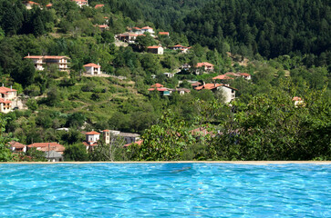Swimming pool with great view to the mountain and village. Exotic vacations. Greece