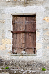 Old wooden window on stone made wall.