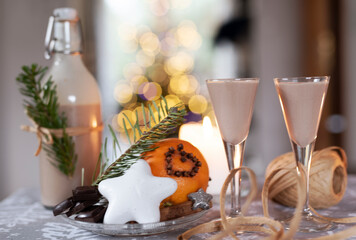 Alcoholic liqueur made from chocolate and coffee in a bottle and glasses. Romantic anniversary and christmas party with bokeh lights. Alcohol and Holidays. 
