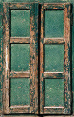 old closed and weathered green wooden window,