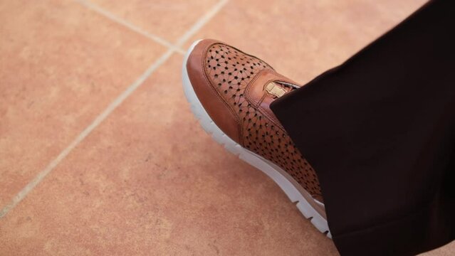 camara lenta de zapato de una persona moviendose al ritmo de una musica