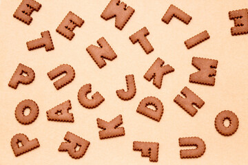Alphabet shaped cookies  are spread out evenly on baking paper. background for advertising