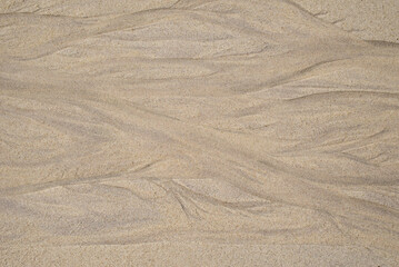 Natural texture of sand. Abstract beautiful drawings on the sand. Paintings in the sand
