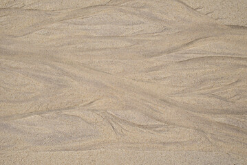 Natural texture of sand. Abstract beautiful drawings on the sand. Paintings in the sand
