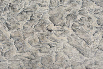 Natural texture of sand. Abstract beautiful drawings on the sand. Paintings in the sand
