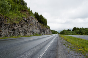 Scenic road along the fjords in Norway. Amazing landscape. Northern nature. Snow-capped mountains. Dramatic clouds. Travel, adventure
