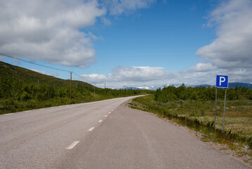 Scenic road along the fjords in Norway. Amazing landscape. Northern nature. Snow-capped mountains. Dramatic clouds. Travel, adventure
