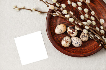 Happy Easter holiday aesthetic template. Blank paper sheet, quail eggs and pussy willow branches on plate on neutral beige background, stylish rustic composition with copy space