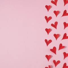 Red paper hearts on pink background. Minimal love concept-