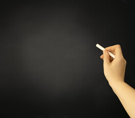 Graphite board by hand on a background with a piece of white chalk. Board for notes or for school. Lessons, teaching, learning, drawing. High quality photo