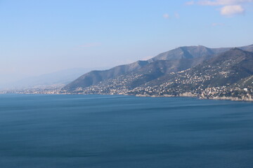 Naklejka premium Camogli, Italy - January 28, 2023: An aerial view to the city of Camogli. Beautiful landscape from the ligurian sea with blue sky and mountains in the background. 