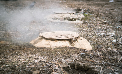 Obraz premium Manholes with fumes on city street in cold weather.