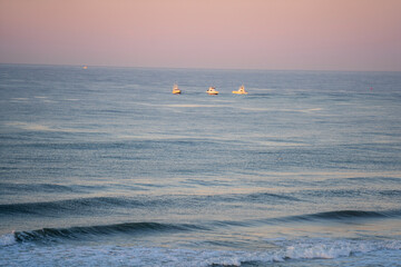 Fishing boats out in the morning sunrise, Three Boats catching bait fish, boat on the sea