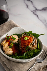 Wild rice and mushroom risotto with sliced chicken breast. Served on a bed of spinach with a couple dollops of marinara sauce.
