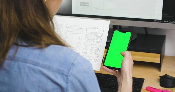 Sketch of wireframe for website. Women designer working on a mobile application, drawing on paper.