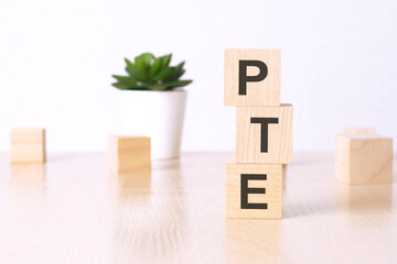 PTE - pearson tests of english - text on wooden cubes on a white background