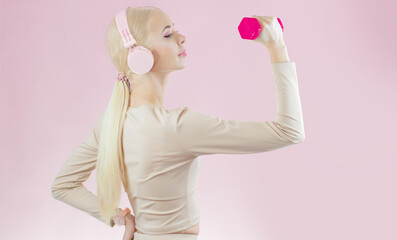 Active happy girl doing fitness with pink dumbbells and listening music on a pink background. Gym Fit Diet