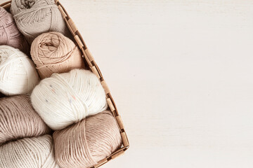 Craft knitting hobby background with yarn in natural colors. Recomforting hobby to reduce stress for cold fall and winter weather. Mock up, copy space, top view