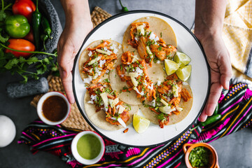 Hands of Mexican woman holding Tacos al pastor food top view in Mexico