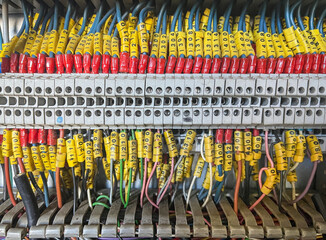interior of an electrical cabinet with a terminal block full of numbered wires, industrial...