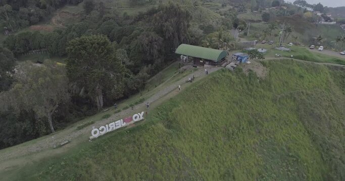 Tourists Walking through a Park with a Sign that Reads "I Love Jerico" in Spanish on a Green Hill on a Cloudy Day - Shot in D-Log 