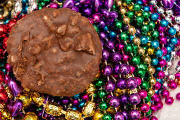 Pralines on top of colorful Mardi Gras beads background with a shallow depth of field