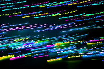 Blurred abstract background. Drawing with light, garlands with multi-colored LED bulbs, shooting while moving at a slow shutter speed.