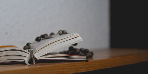 Catholic rosary lying on a prayer book.