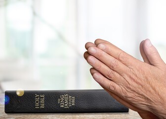 Human's Hand pray with Bible Book