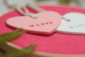 Close-up of heart shaped ceramic ornaments on an embroidery hoop