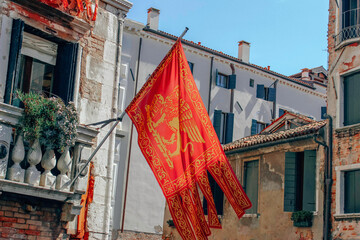 Venetian flag with the lion of Saint Mark on the old building of the city, Venice, Italy