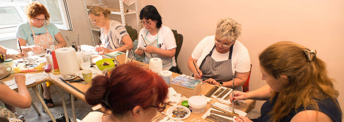 Women in art workshop making decoupage boxes	