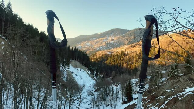 Static landscape panorama hiking poles on hiking trail with panorama of snowy caucasus mountains in bright warm spring evening during sunset. Snow melts springtime arrive