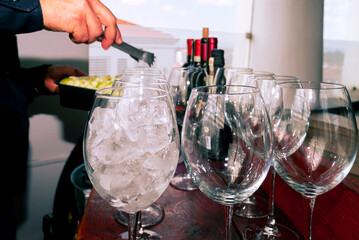 Drink prepared with wine and orange juice accompanied with ice and fresh fruits, festive event in restaurant area, latin man preparing drink.