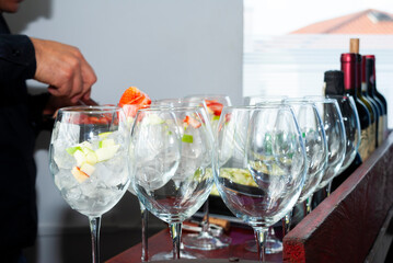 Drink prepared with wine and orange juice accompanied with ice and fresh fruits, festive event in restaurant area, latin man preparing drink. - 567875987