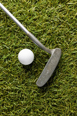 Close up of white golf ball and golf club on grass with copy space