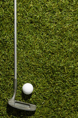 Close up of white golf ball and golf club on grass with copy space