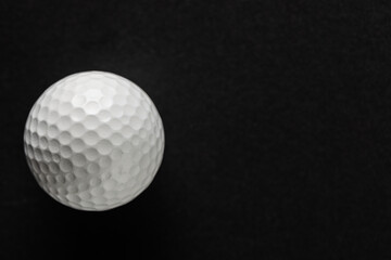 Close up of white golf ball with copy space on black background
