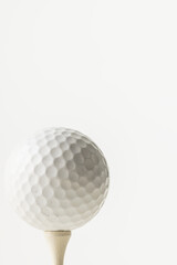 Close up of white golf ball on golf tee with copy space on white background