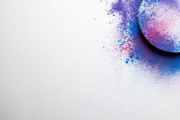 Close up of multi coloured powder with white circle and copy space on white background