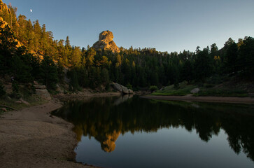 Unique rock formation reflected in calm river water at dusk